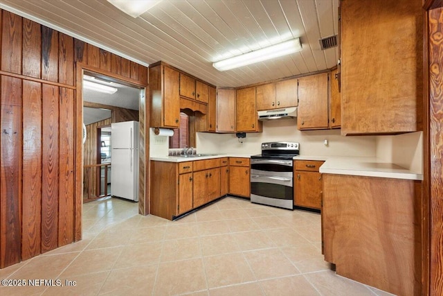 37206 Cypress Ln, Hilliard, FL 32046 - kitchen with range with two ovens, freestanding refrigerator, under cabinet range hood, brown cabinets, and light countertops