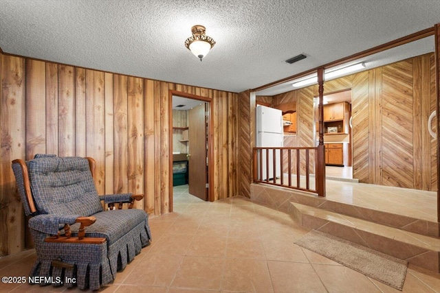 37206 Cypress Ln, Hilliard, FL 32046 - living area with wood walls, a textured ceiling, tile patterned floors, and an upstairs landing