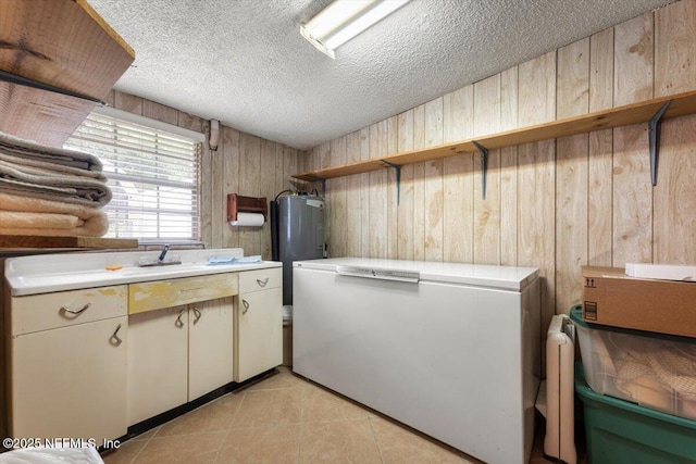 37206 Cypress Ln, Hilliard, FL 32046 - kitchen featuring light countertops, wooden walls, water heater, a textured ceiling, and open shelves