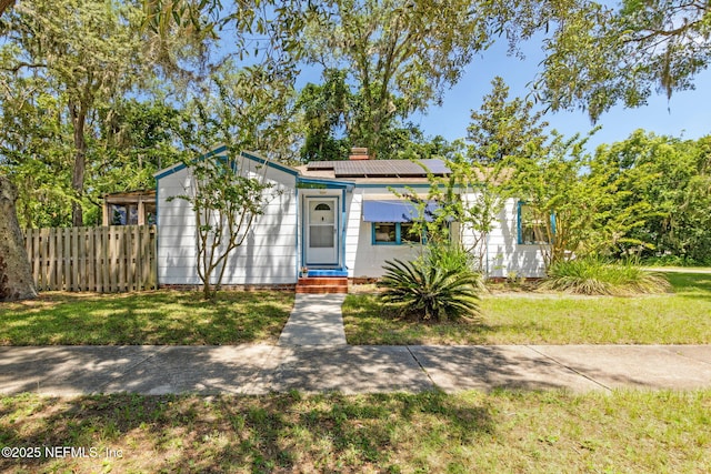 112 S 14th St, Fernandina Beach, FL 32034 - view of front of home featuring roof mounted solar panels and a chimney