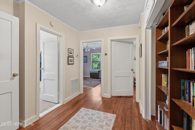 112 S 14th St, Fernandina Beach, FL 32034 - corridor with wood finished floors, a textured ceiling, and ornamental molding