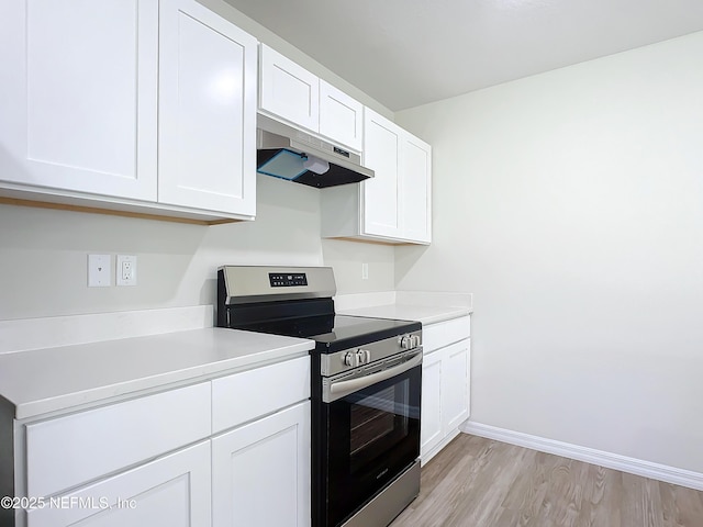 29 Wood Ash Ln, Palm Coast, FL 32164 - kitchen with stainless steel electric range, under cabinet range hood, light wood-style flooring, white cabinetry, and light countertops