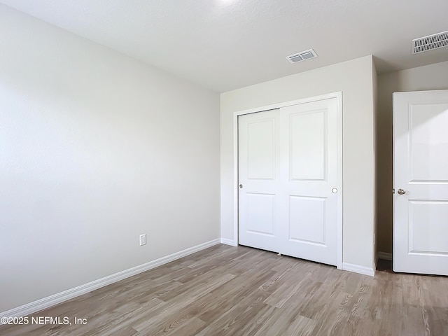 29 Wood Ash Ln, Palm Coast, FL 32164 - unfurnished bedroom featuring light wood-type flooring and a closet