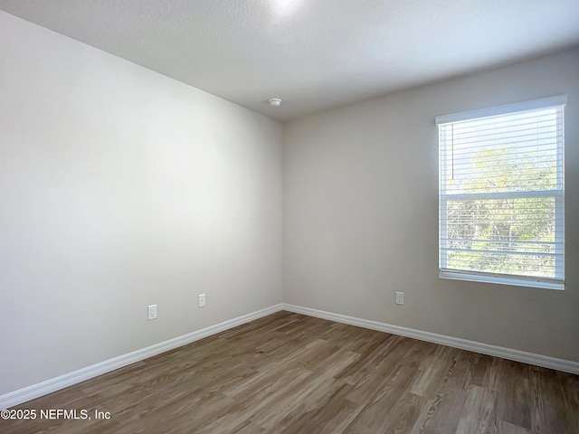 29 Wood Ash Ln, Palm Coast, FL 32164 - spare room featuring wood finished floors and baseboards