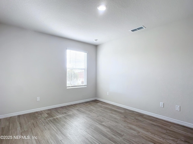 29 Wood Ash Ln, Palm Coast, FL 32164 - spare room featuring wood finished floors and a textured ceiling