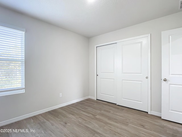 29 Wood Ash Ln, Palm Coast, FL 32164 - unfurnished bedroom featuring light wood-style flooring and a closet