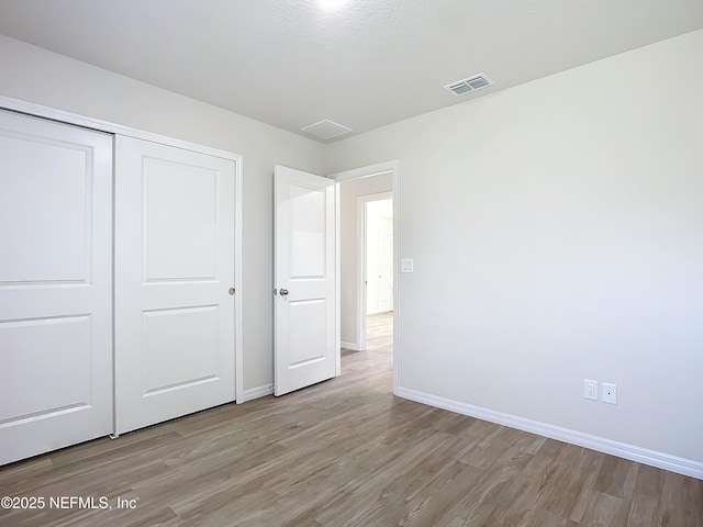 29 Wood Ash Ln, Palm Coast, FL 32164 - unfurnished bedroom featuring light wood finished floors and a closet