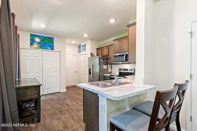 81 Scotch Pebble Dr, Saint Augustine, FL 32259 - kitchen with stainless steel appliances, dark wood-style flooring, a breakfast bar area, a peninsula, and light countertops