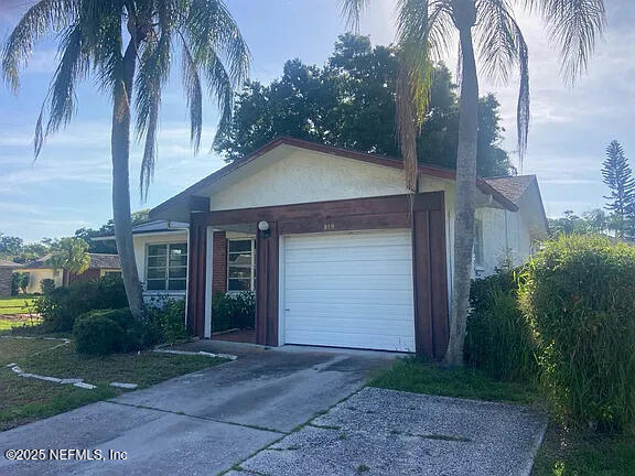 819 Helmsman Way, Palm Harbor, FL 34685 - ranch-style house with driveway and an attached garage