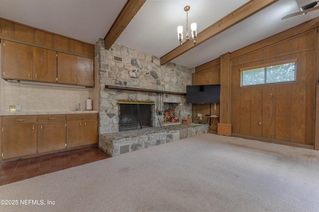 5042 Brighton Dr, Jacksonville, FL 32217 - unfurnished living room with a stone fireplace, a chandelier, and dark carpet