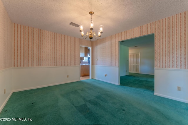 5042 Brighton Dr, Jacksonville, FL 32217 - empty room featuring wallpapered walls, a chandelier, carpet, a textured ceiling, and wainscoting