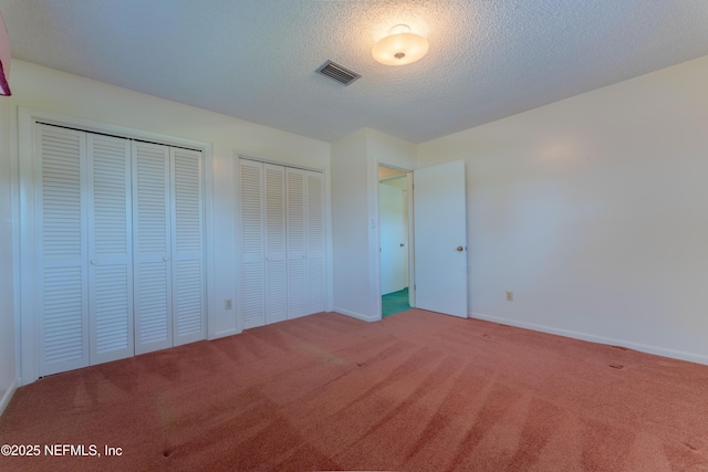 5042 Brighton Dr, Jacksonville, FL 32217 - unfurnished bedroom featuring carpet flooring, two closets, and a textured ceiling