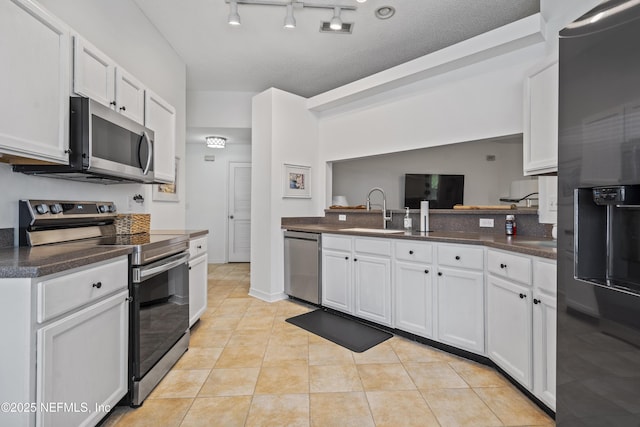 1853 Weston Cir, Fleming Island, FL 32003 - kitchen featuring appliances with stainless steel finishes, dark countertops, white cabinetry, and light tile patterned floors