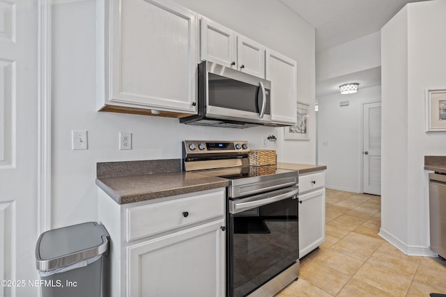 1853 Weston Cir, Fleming Island, FL 32003 - kitchen featuring stainless steel appliances, dark countertops, light tile patterned floors, and white cabinets