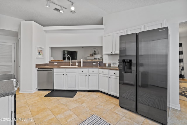 1853 Weston Cir, Fleming Island, FL 32003 - kitchen with dishwasher, refrigerator with ice dispenser, dark countertops, white cabinetry, and a textured ceiling
