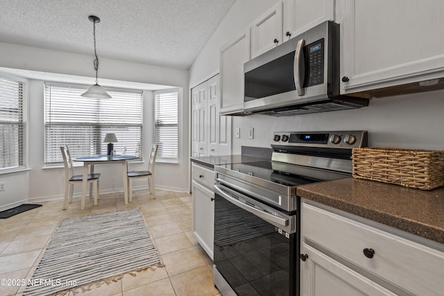 1853 Weston Cir, Fleming Island, FL 32003 - kitchen featuring appliances with stainless steel finishes, dark countertops, hanging light fixtures, light tile patterned floors, and a textured ceiling