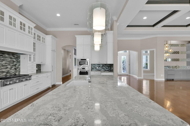 452 Deer Valley Dr, Ponte Vedra, FL 32081 - kitchen featuring stainless steel gas stovetop, arched walkways, ornamental molding, decorative backsplash, and white cabinetry