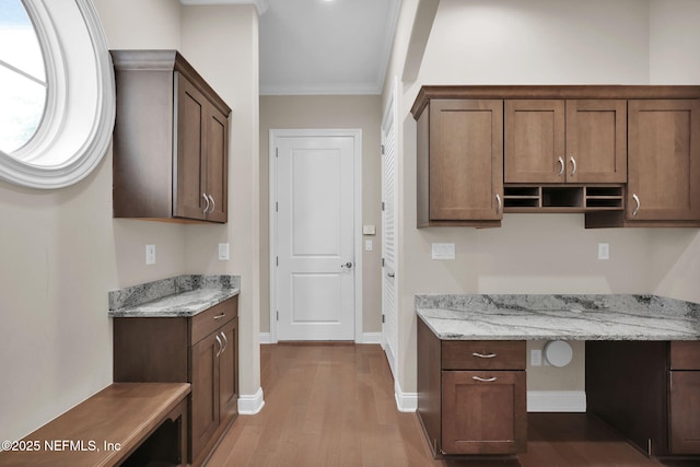 452 Deer Valley Dr, Ponte Vedra, FL 32081 - kitchen featuring wood finished floors, built in study area, crown molding, light stone countertops, and open shelves