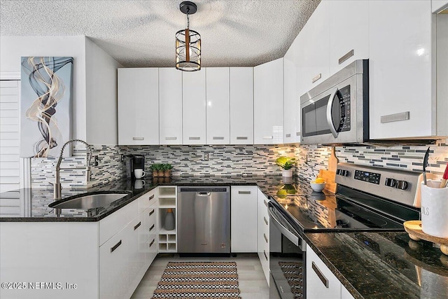 35 Turtleback Trl, Ponte Vedra Beach, FL 32082 - kitchen with stainless steel appliances, backsplash, a textured ceiling, white cabinets, and pendant lighting