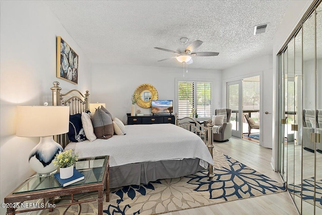 35 Turtleback Trl, Ponte Vedra Beach, FL 32082 - bedroom with light wood-style flooring, access to exterior, a ceiling fan, and a textured ceiling