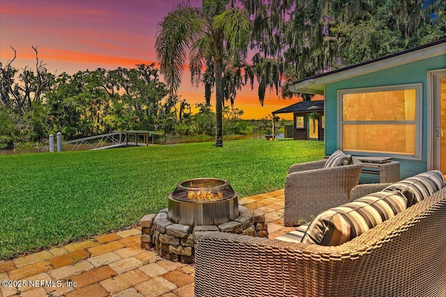 2638 W End St, Jacksonville, FL 32233 - patio terrace at dusk featuring an outdoor fire pit, a lawn, and a patio
