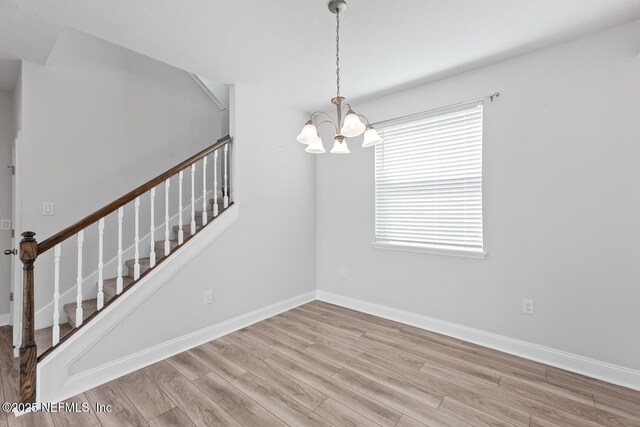 117 Redbud Ln, Yulee, FL 32097 - empty room with stairway, a chandelier, and wood finished floors