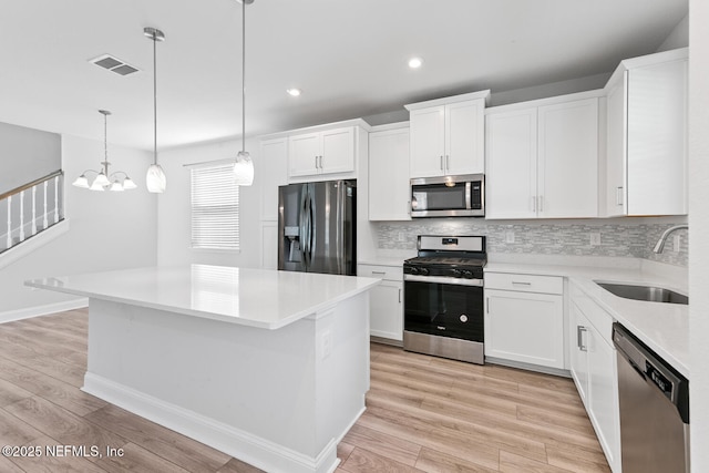 117 Redbud Ln, Yulee, FL 32097 - kitchen with appliances with stainless steel finishes, tasteful backsplash, light wood-style floors, light countertops, and white cabinets