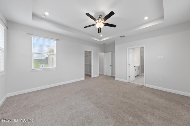 117 Redbud Ln, Yulee, FL 32097 - unfurnished bedroom with a raised ceiling, recessed lighting, light carpet, a walk in closet, and ensuite bath