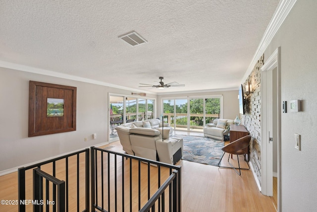 136 Sherwood Ave, Saint Augustine, FL 32084 - living room featuring light wood-style flooring, crown molding, a textured ceiling, and a ceiling fan