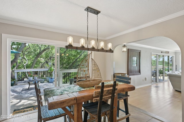 136 Sherwood Ave, Saint Augustine, FL 32084 - dining area with arched walkways, ornamental molding, healthy amount of natural light, light tile patterned flooring, and a textured ceiling