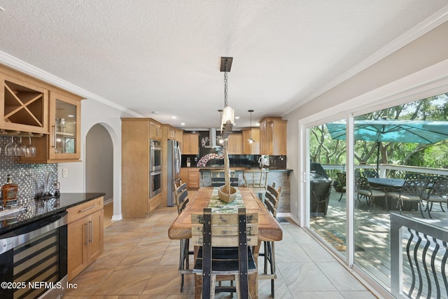 136 Sherwood Ave, Saint Augustine, FL 32084 - dining area featuring wine cooler, a bar, ornamental molding, arched walkways, and recessed lighting