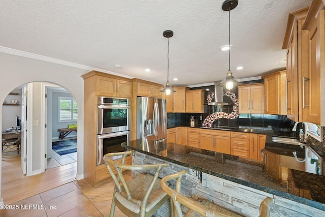 136 Sherwood Ave, Saint Augustine, FL 32084 - kitchen with stainless steel appliances, wall chimney exhaust hood, arched walkways, decorative backsplash, and a peninsula