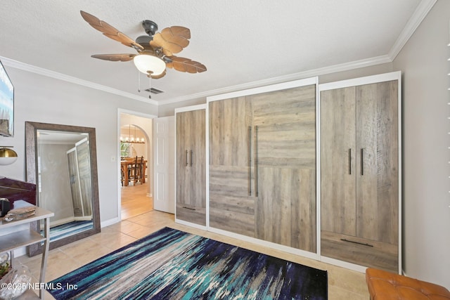 136 Sherwood Ave, Saint Augustine, FL 32084 - bedroom with tile patterned flooring, ornamental molding, a ceiling fan, and a chandelier