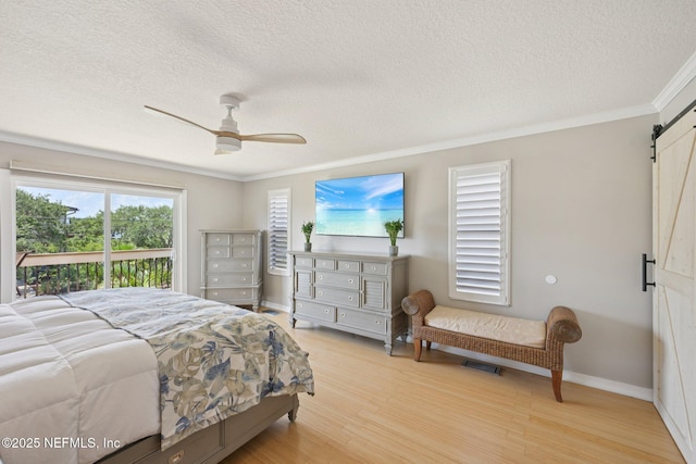 136 Sherwood Ave, Saint Augustine, FL 32084 - bedroom with a barn door, access to outside, a textured ceiling, ornamental molding, and light wood finished floors