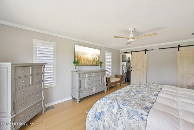136 Sherwood Ave, Saint Augustine, FL 32084 - bedroom with a barn door, light wood-style flooring, ornamental molding, and ceiling fan