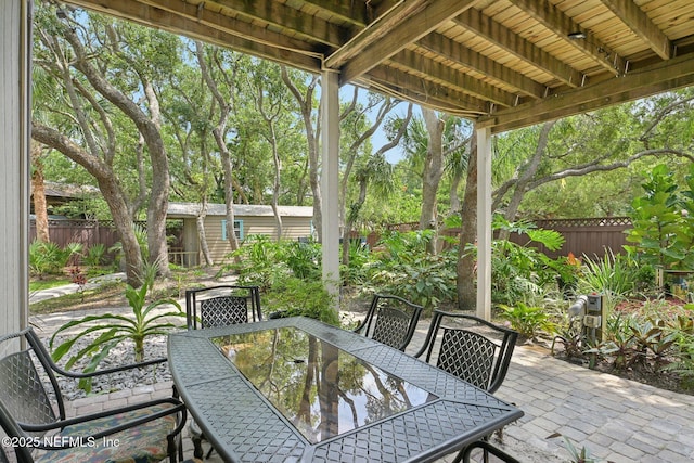 136 Sherwood Ave, Saint Augustine, FL 32084 - fenced backyard featuring outdoor dining area, a patio, and view of wooded area