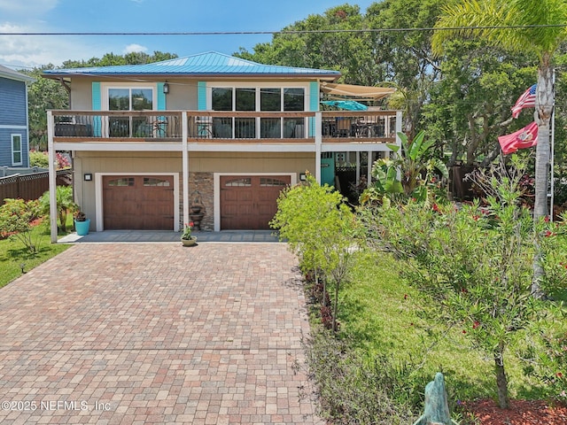 136 Sherwood Ave, Saint Augustine, FL 32084 - view of front facade with decorative driveway, a garage, a metal roof, and stone siding