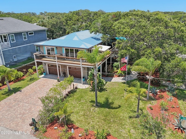 136 Sherwood Ave, Saint Augustine, FL 32084 - view of front of property featuring decorative driveway, a garage, a front lawn, a metal roof, and a forest view