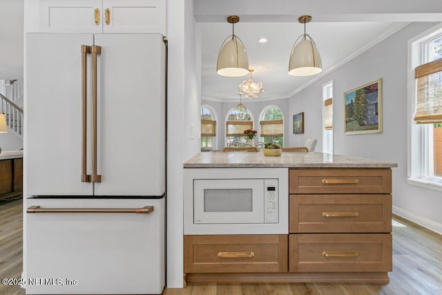 50 17th St, Atlantic Beach, FL 32233 - kitchen with white appliances, crown molding, plenty of natural light, light wood finished floors, and pendant lighting