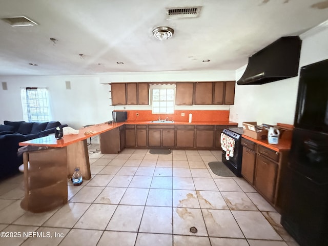 427 Crestwood St, Jacksonville, FL 32208 - kitchen featuring wall chimney range hood, black appliances, light tile patterned floors, and open floor plan