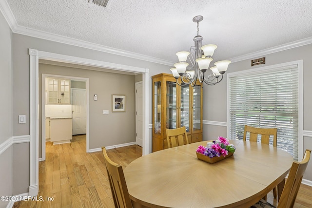 12137 Dividing Oaks Trl E, Jacksonville, FL 32223 - dining room featuring a chandelier, a textured ceiling, light wood-style floors, and crown molding