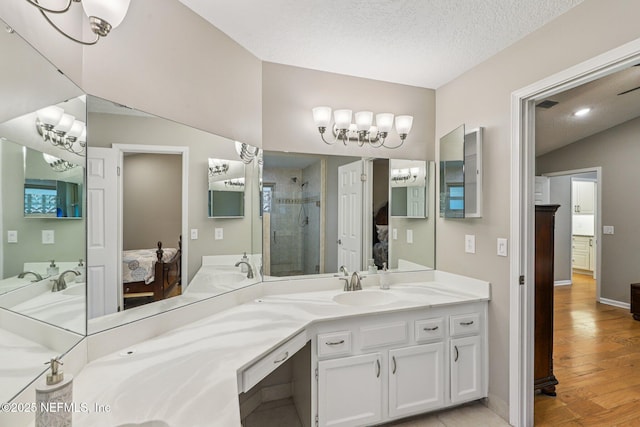 12137 Dividing Oaks Trl E, Jacksonville, FL 32223 - full bathroom with ensuite bath, a shower stall, a chandelier, wood finished floors, and a textured ceiling
