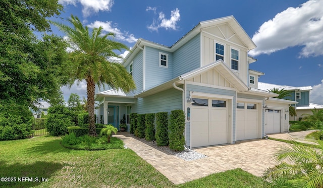 651 Rum Runner Way, Saint Johns, FL 32259 - view of front of house featuring board and batten siding, decorative driveway, and a garage