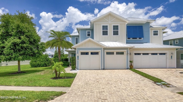 651 Rum Runner Way, Saint Johns, FL 32259 - view of front of property featuring a garage, driveway, a front yard, board and batten siding, and a standing seam roof