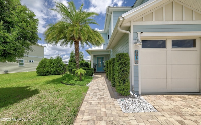 651 Rum Runner Way, Saint Johns, FL 32259 - doorway to property featuring an attached garage, a yard, and board and batten siding