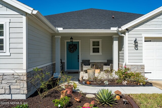 665 Flach Dr, Saint Johns, FL 32259 - doorway to property featuring covered porch, an attached garage, roof with shingles, and stone siding