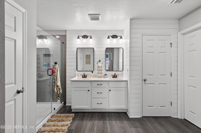 665 Flach Dr, Saint Johns, FL 32259 - full bath with wood finished floors, a shower stall, double vanity, and a textured ceiling