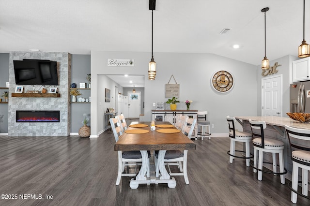 665 Flach Dr, Saint Johns, FL 32259 - dining area featuring dark wood-style floors, vaulted ceiling, and a large fireplace