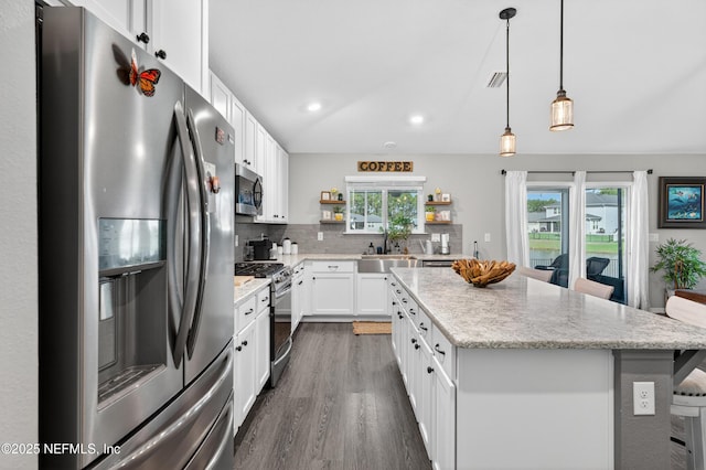665 Flach Dr, Saint Johns, FL 32259 - kitchen featuring stainless steel appliances, open shelves, a kitchen island, dark wood finished floors, and tasteful backsplash