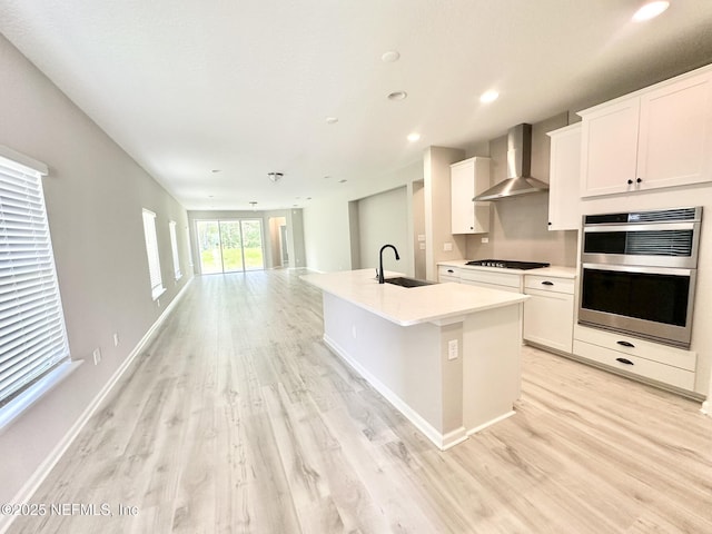 356 Bermudez Way, Saint Augustine, FL 32095 - kitchen with wall chimney exhaust hood, light wood-style flooring, double oven, white cabinetry, and recessed lighting